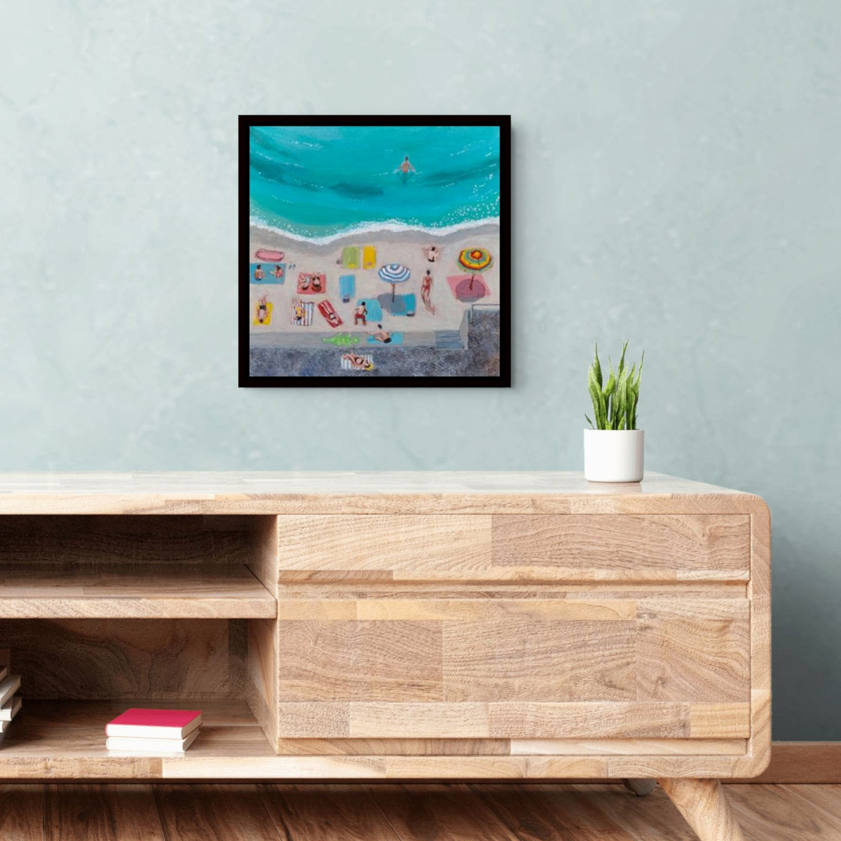 A whimsical and colorful framed canvas print of Day at the Beach by artglober in a livingroom.