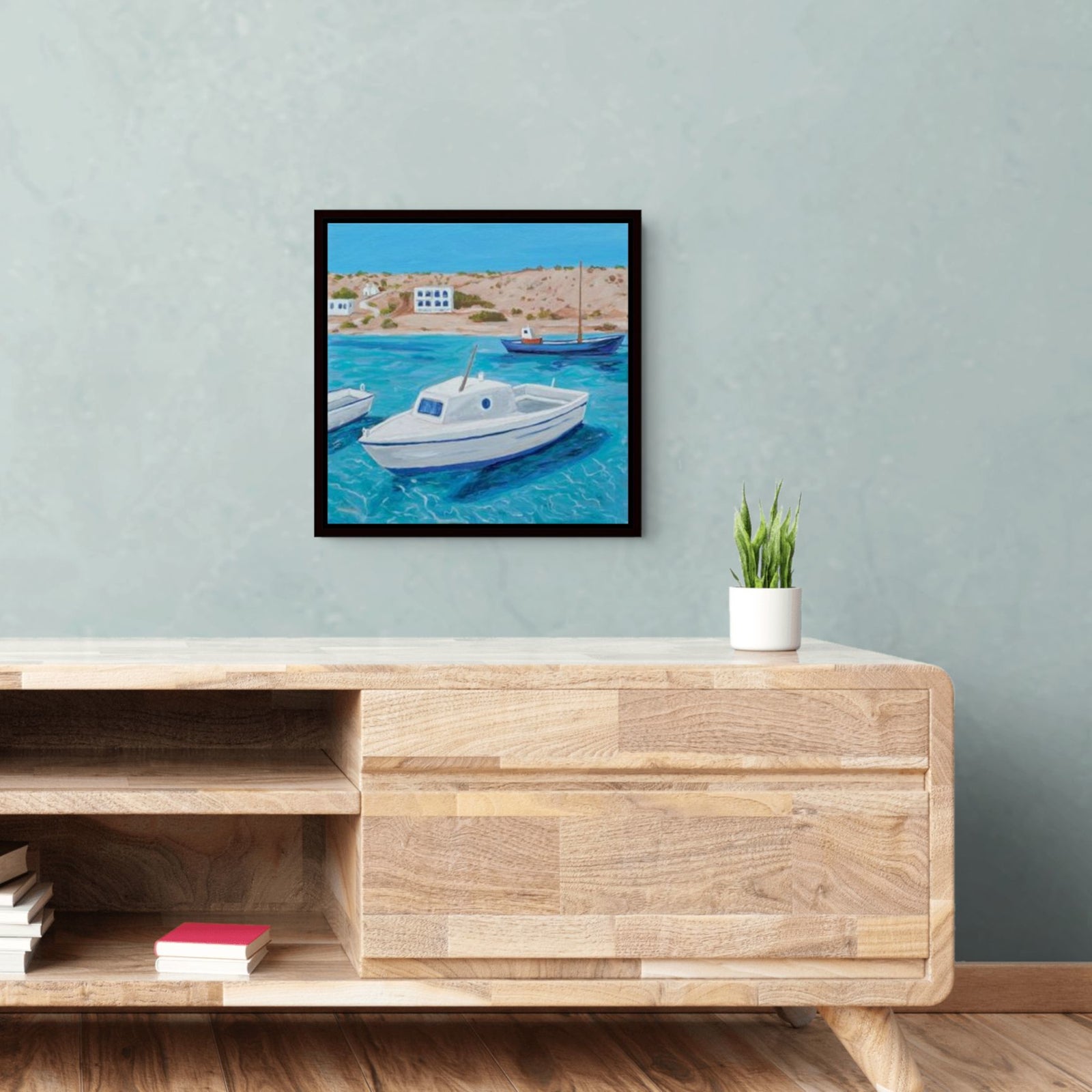 A colorful framed canvas print of the Greek islands by Artglober hangs in a living room.